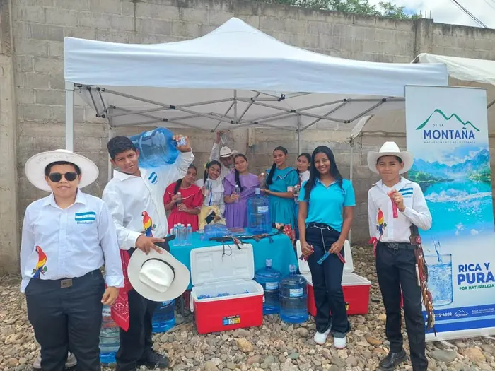 Niños con trajes típicos y botellas de Agua de la Montaña