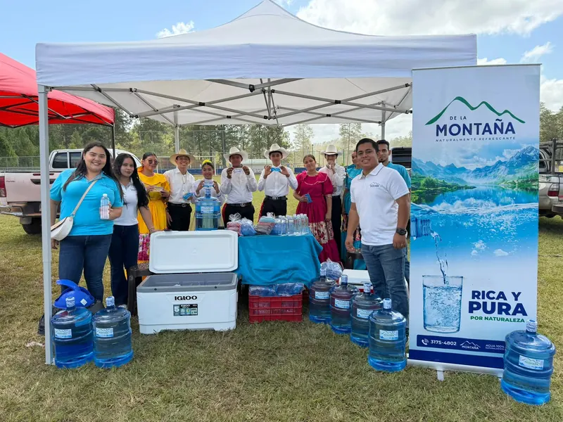 Stand de Agua de la Montaña con garrafones y el equipo
